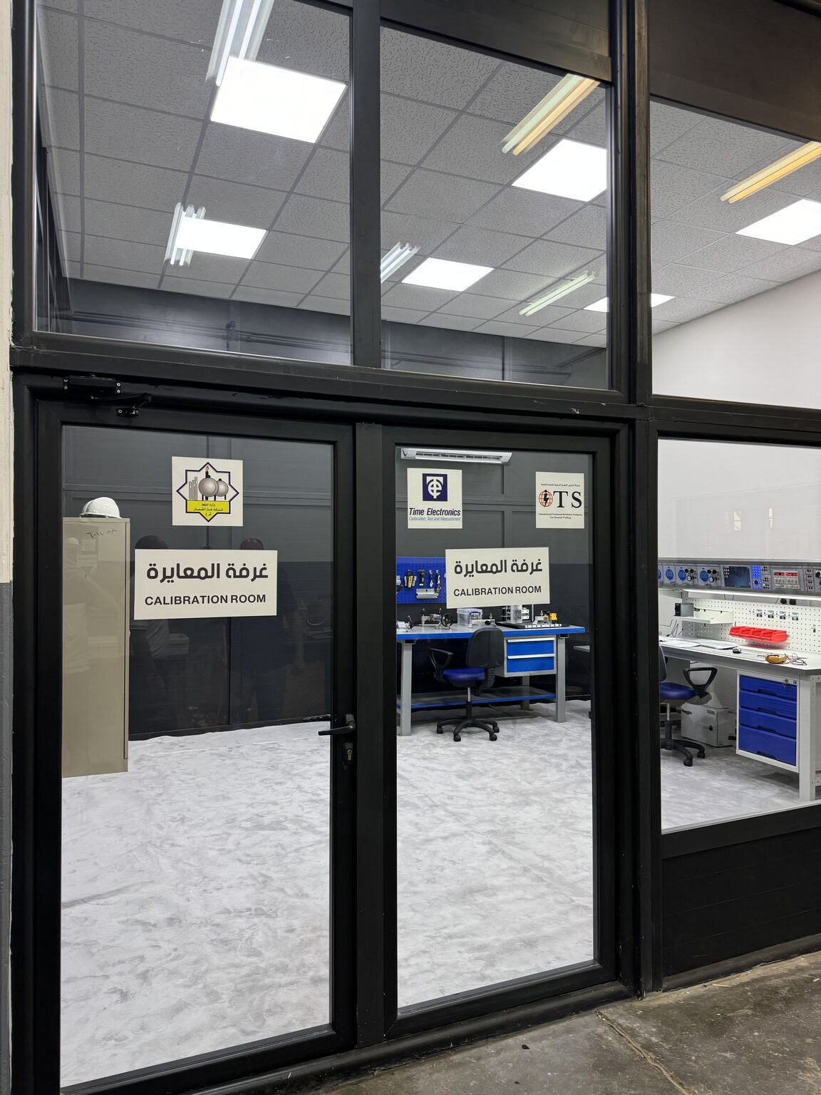 The glass doors of the calibration room, signed North Gas Company, Time Electronics and ITS.