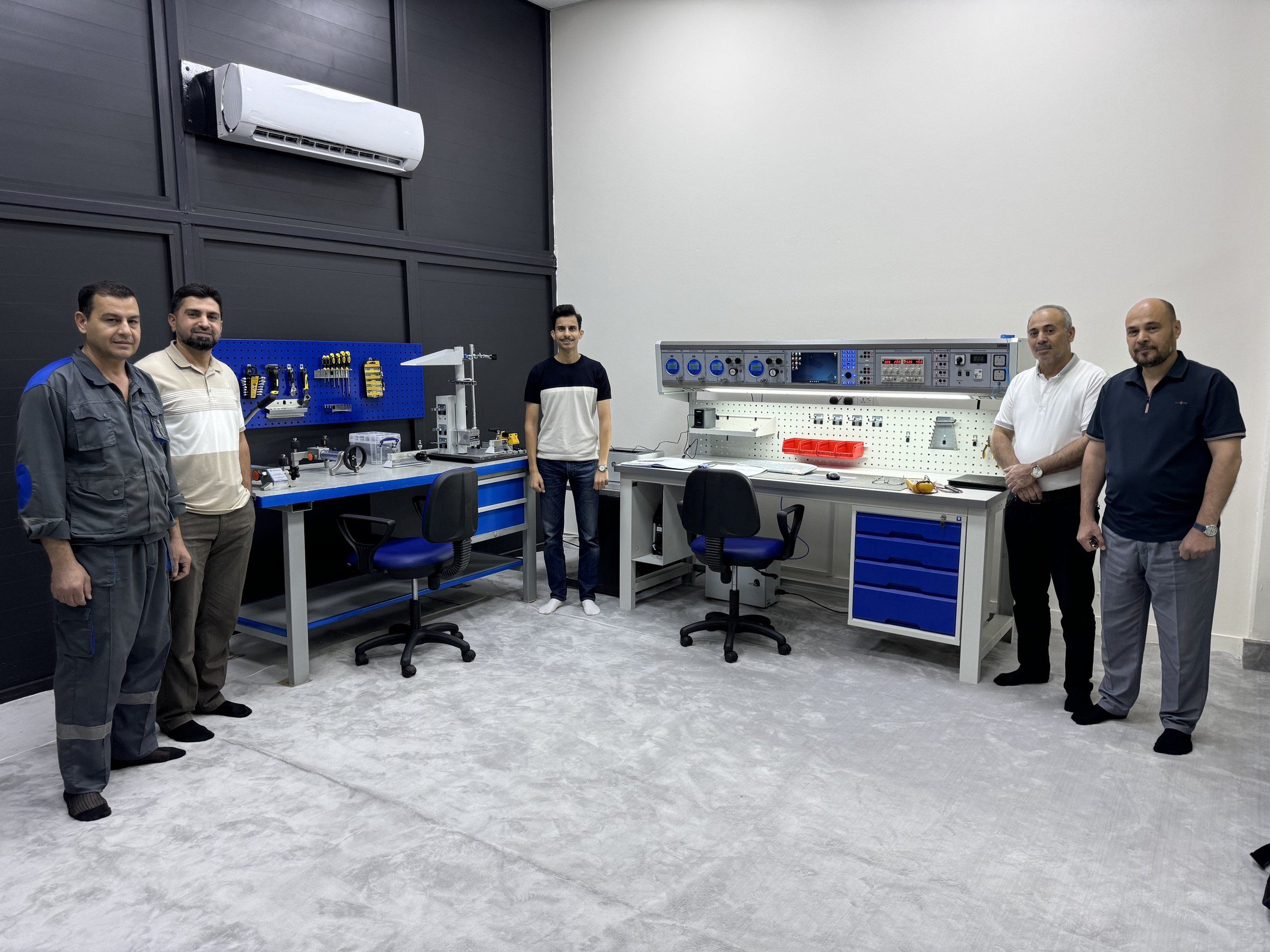 Omar Farooq Al Obaidi with the project team beside the CalBench in the finished room.