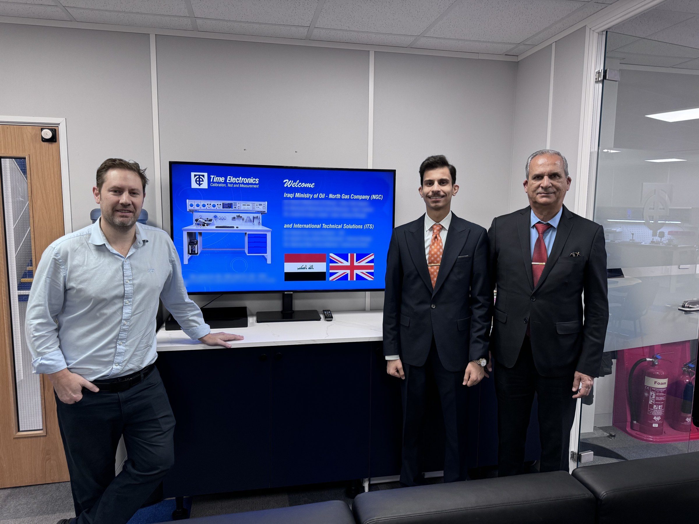 Robert Bailey, Omar Farooq Al Obaidi and Farooq Mahmood Al Obaidi in front of the Time Electronics welcome screen.